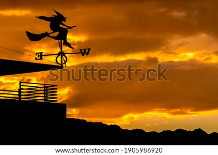 Silhouette of weather vane with witch flying on broomstick. Weather vane is instrument showing direction of wind - typically used as architectural ornament to the highest point of a building