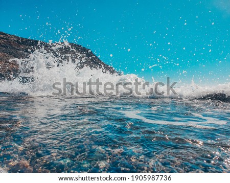 Waves crashing on the rocky beach. Low angle view to the shore of the Atlantic ocean with volcanic rocks. Travel concept. Holiday. Summer 