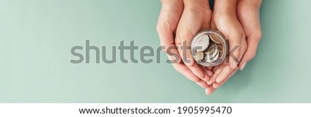 child and parent hands holding money jar, fundraising charity donation, saving, family finance plan concept Royalty-Free Stock Photo #1905995470