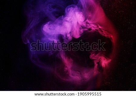 Art photo of purple smoke moves on black background. Beautiful swirling colorful smoke.