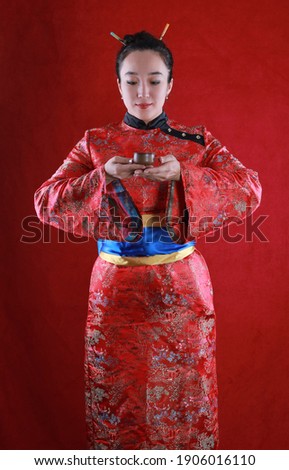 portrait of a japanese girl in a red kimono at a tea ceremony