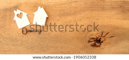 an old oak board with a white house as a symbol