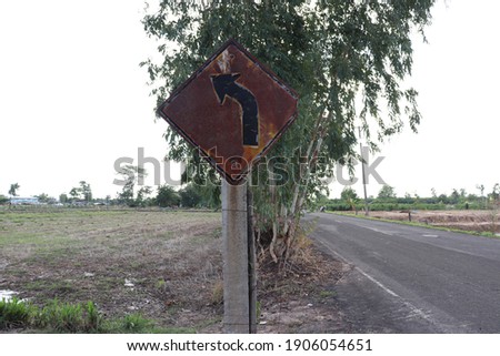 A rusty traffic sign on the side of the road
