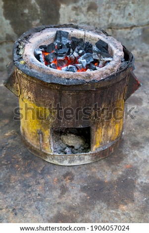 This purpose built stove is often used by street food stalls and is highly energy efficient relative to the common three stone fire.The purpose built stove not only saves money but also uses less fuel Royalty-Free Stock Photo #1906057024