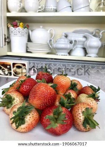 Fresh organic sweet strawberries group in the white plate with the sweet vintage corner in the kitchen