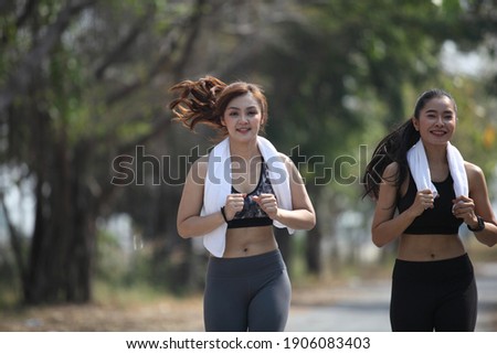runner - woman running outdoors training for marathon run. Beautiful fit asian fitness model in her 20s.Sporty woman runner. Photo of attractive woman in fashionable sportswear. Dynamic movement. 