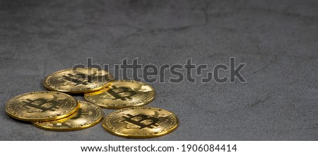 A pile of golden bitcoin on the left side of the dark background