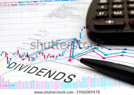 DIVIDENDS text on documents with graphs, charts, calculator, pen, financial concept background. Royalty-Free Stock Photo #1906089478