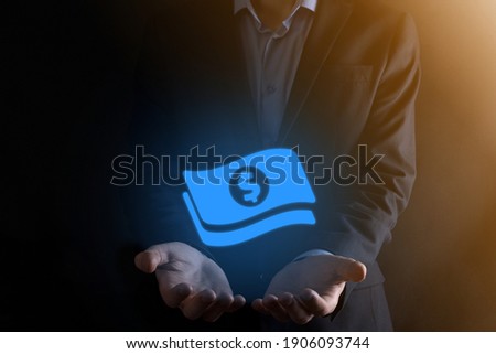 Businessman man holding money coin icon in his hands.Growing money concept for business investment and finance. USD or US dollar on dark tone background