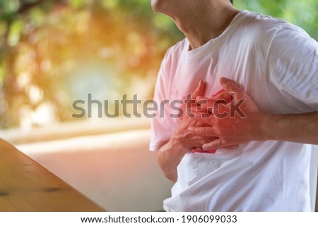 Heart burn or Pericarditis disease concept. Man's hands on his chest suffering on chest pain, heart attack, Lung Problems, or Myocarditis. Pulmonary embolism day Royalty-Free Stock Photo #1906099033