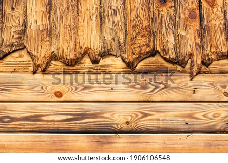 Wooden natural, textured, burnt, boards are stacked next to each other, background. Place for text.
