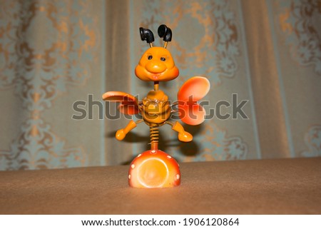 The toy on the springs is a bee of orange color.