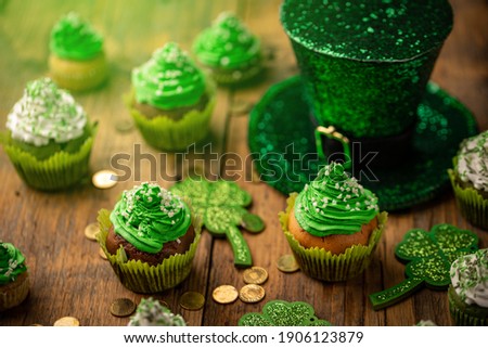 Decorated cupcake and hat on wooden table. St. Patrick's Day celebration