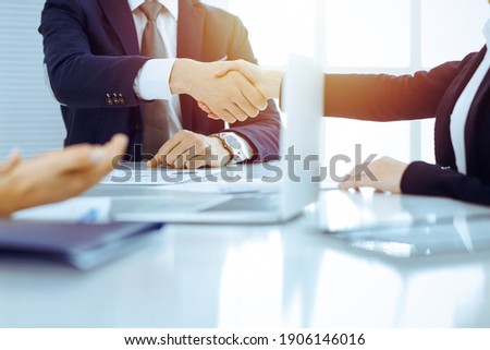 Businesspeople or lawyers shaking hands finishing up meeting or negotiation in sunny office. Business handshake and partnership Royalty-Free Stock Photo #1906146016