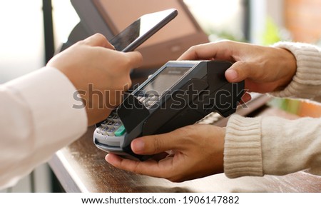 Customer using phone for payment at cafe restaurant, cashless technology and money transfer concept