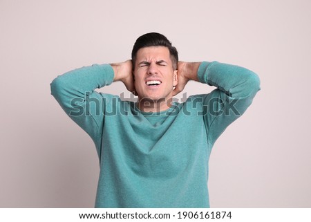 Portrait of stressed man on light background