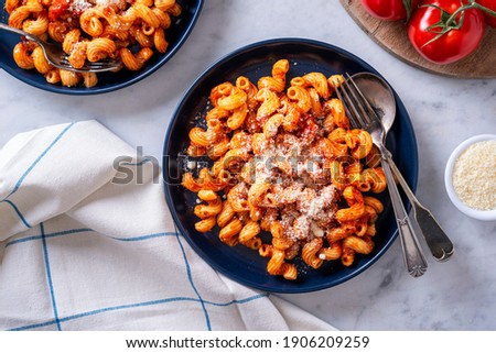 Delicious cavatappi pasta with tomato sauce and parmesan cheese. Royalty-Free Stock Photo #1906209259