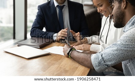 Confirming deal. Close up of happy african husband wife signing up contract in presence of lawyer financial advisor. Young black couple buy real estate make investment after getting agent consultation