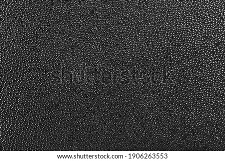 rough black plastic finish microstructure with micro bubbles surface texture and background Royalty-Free Stock Photo #1906263553