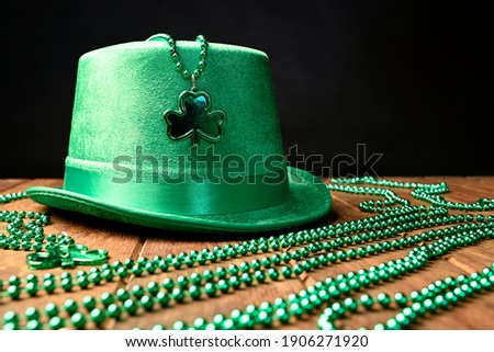 Concept of St. Patrick. Green hat and necklaces on a black background.