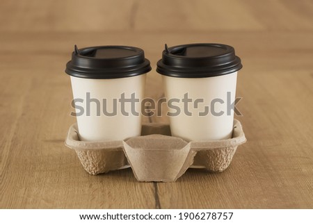 Coffee to go. Two white paper cups with a blank space for the logo.