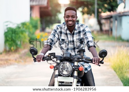 African biker riding a motorcycle with smile and happy