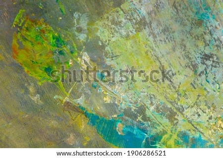 colorful creative motley background: smudged residues of oil paints on a wooden palette, short focus, selective blur