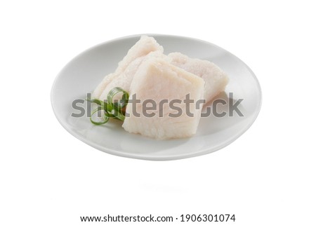 pieces of boiled pangasius fish fillet in white dish on white background.
