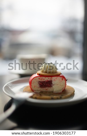 
sliced ​​red cheesecake with strawberry cheesecake with cappuccino on a black table