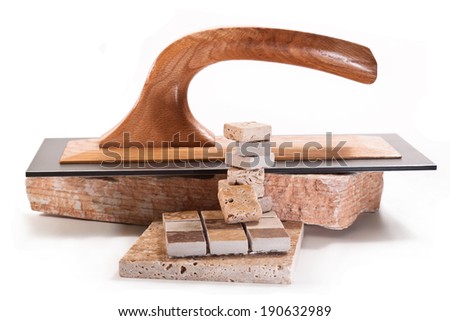 Stack of decorative tile, stone and trowel on a white background