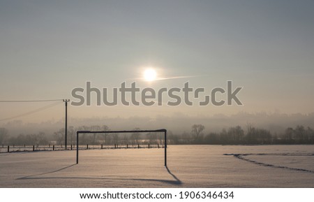 Abandoned soccer field, seen in the morning, covered in snow