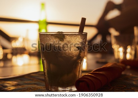 Photo of cocktail with sunset in background