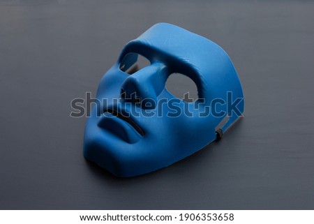 Blue face mask on dark background.