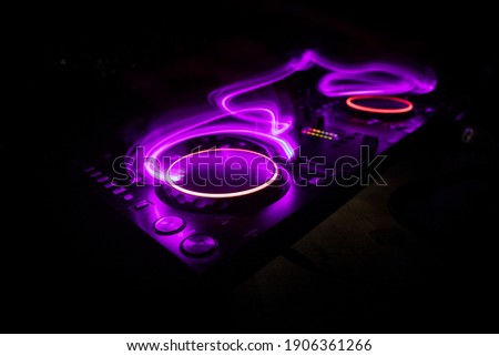 Club music concept. DJ console deejay-mixing desk in dark with colorful light. Mixer equipment entertainment DJ station. Selective focus Royalty-Free Stock Photo #1906361266