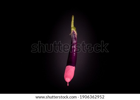 Eggplant isolated floating with pink dripping paint. Front side. Black background. Creative food concept