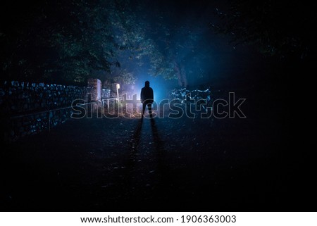 Silhouette of person standing in the dark forest with light. Horror halloween concept. strange silhouette in a dark spooky forest at night