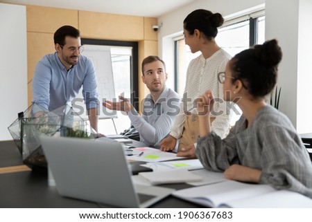 Diverse business team discussing project at corporate briefing in boardroom. Millennial colleagues meeting for brainstorming, sharing ideas, collaborating on startup together. Teamwork concept Royalty-Free Stock Photo #1906367683
