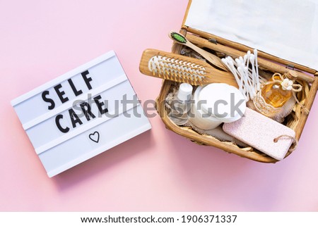 Self-care word on lightbox on pink background flat lay. Natural skin care products. Take care of yourself