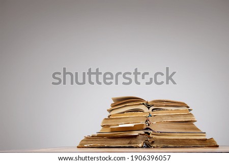 there are many old open books with bookmarks on a wooden table, on a gray background. High quality photo