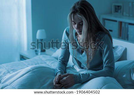 Depressed woman awake in the night, she is exhausted and suffering from insomnia Royalty-Free Stock Photo #1906404502