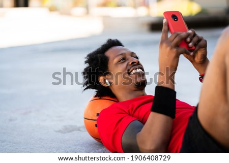 Athlete man using his mobile phone.