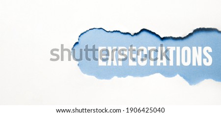 inscription Expectations word on blue torn papper. Royalty-Free Stock Photo #1906425040