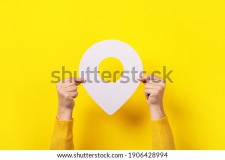 white map pointer 3d pin  in hand over yellow background Royalty-Free Stock Photo #1906428994