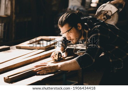 Carpenter man attend to making masterpiece woodworks handcrafted furniture fine measure in wood workshop. Royalty-Free Stock Photo #1906434418