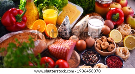 Assorted organic food products on wooden kitchen table. Royalty-Free Stock Photo #1906458070