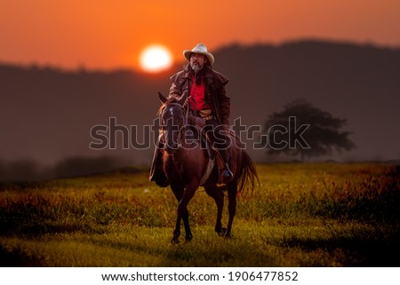 Cowboy horseback riding transportation at sunset time with sunlight ray sky background.
