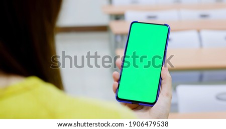 asian woman use green screen smartphone in the classroom at school