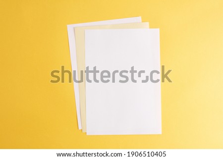Empty white papers on the yellow background
