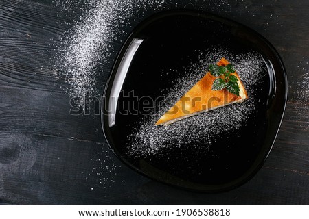 A nice photo of a piece of cake on a black powdered plate .