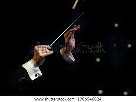 Hands of the conductor of a symphony orchestra closeup Royalty-Free Stock Photo #1906546024